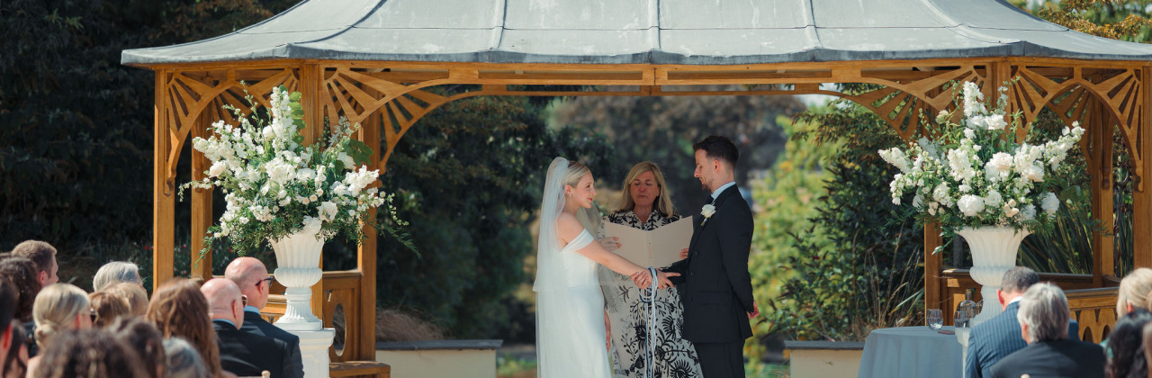 Sam White Celebrant stands with a couple just before they tie the know during their handfasting ceremony.