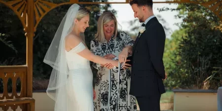Sam White Celebrant forms the knot in a couple's handfasting ceremony.