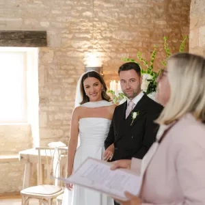 A couple standing with their celebrant in a horse shoe formation during their wedding ceremony at Ivy Lodge in the Cotswolds.